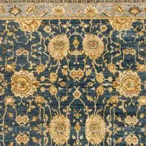 A close-up of a Couristan Easton Adaline area rug in navy and cream, featuring a detailed, traditional floral pattern with large, ornate cream-colored blossoms and intricate foliage on a dark navy background